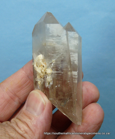 Twin quartz crystals with bits of feldspar attached Twin quartz crystals with bits of feldspar attached