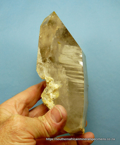 Large, light smoky quartz crystal with several rutile inclusions, and feldspar Large, light smoky quartz crystal with several rutile inclusions, and feldspar